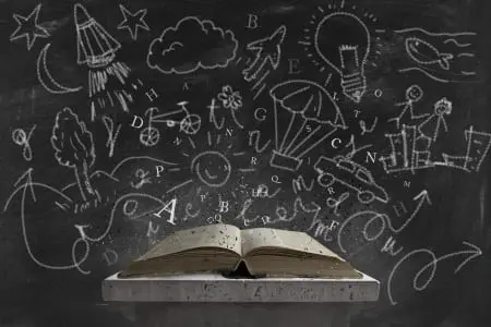 Open book on podium with chalkboard scribbling in background. Photo licensed from 123rf.