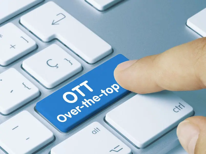 OTT (Over-the-top) Written on Blue Key of Metallic Keyboard. Finger pressing key.