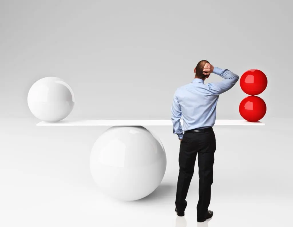 Thinking caucasian man and 3d balanced balls for Kajabi vs. Teachable concept