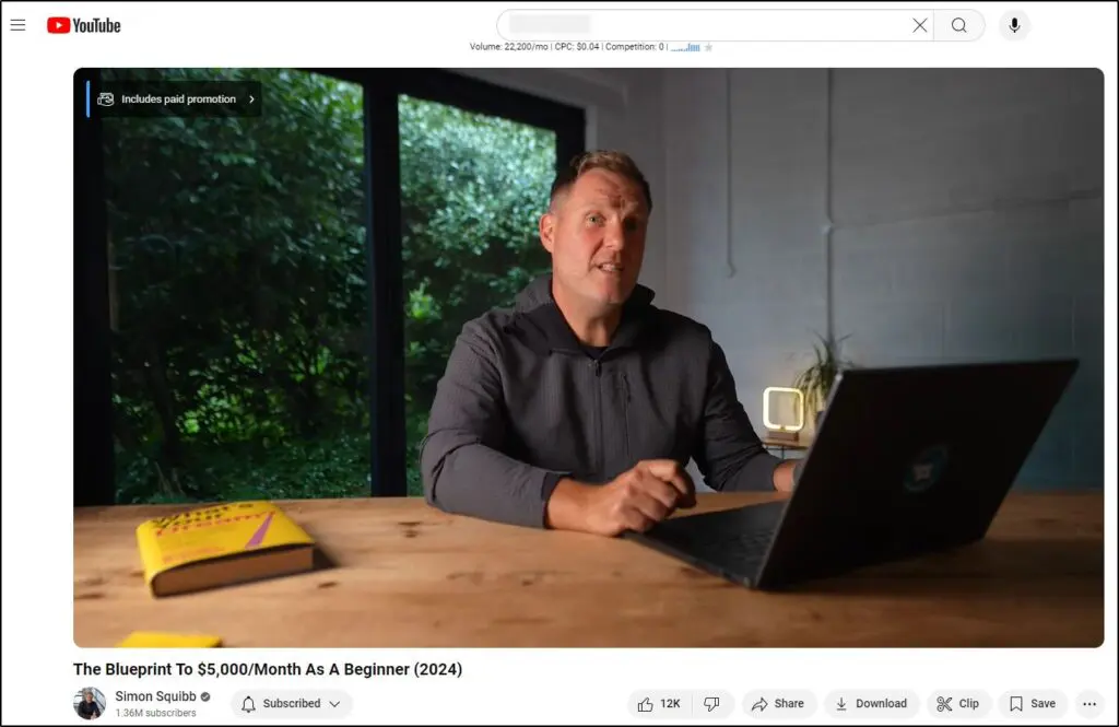 Simon Squibbb sitting in front of laptop at  a table on his channel