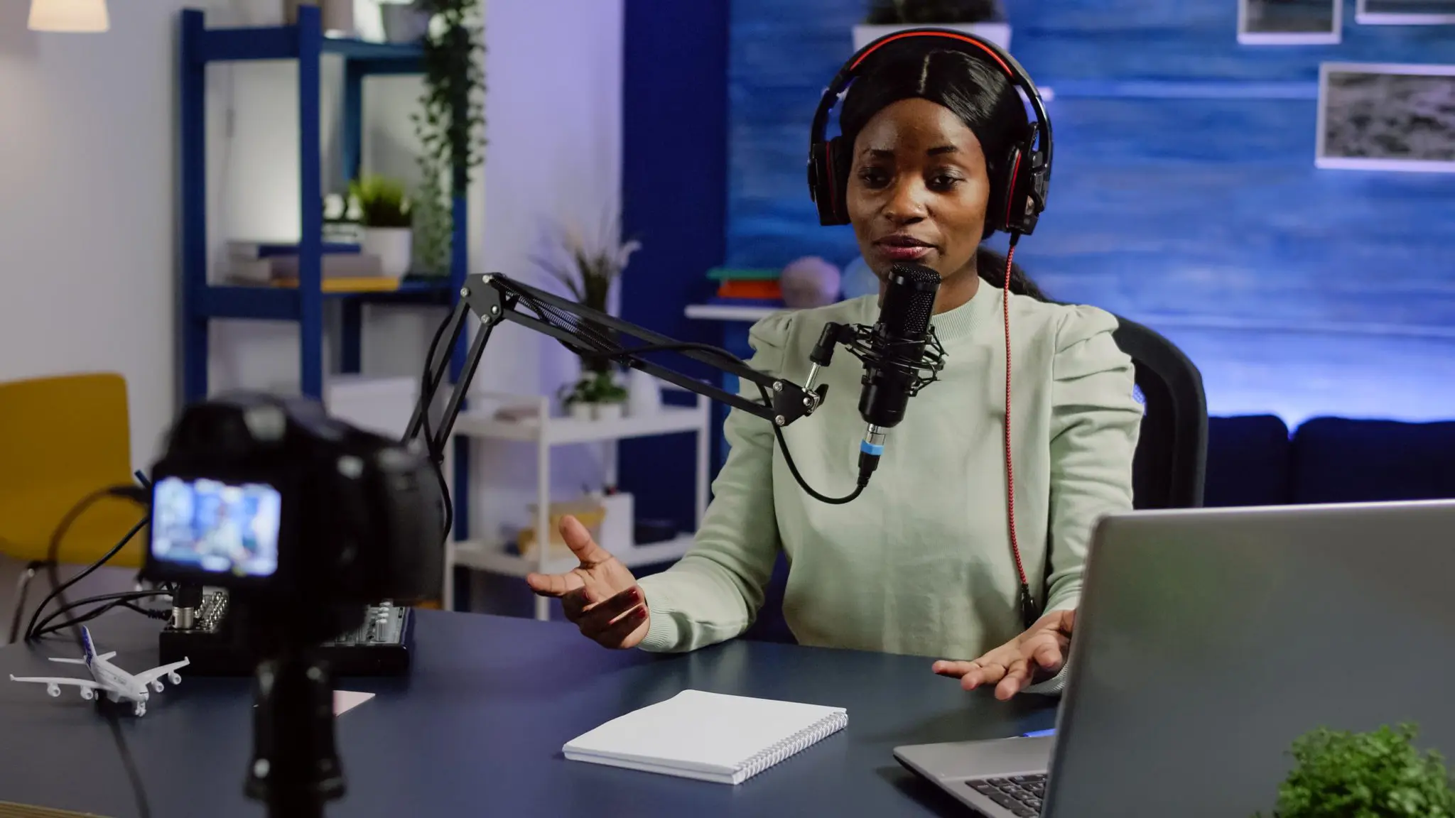 Portrait of woman talking with audience looking at professional video camera working in podcast home studio. Content creator recording podcast, speaking during livestreaming