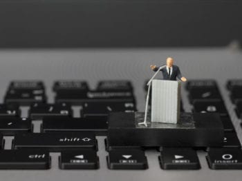 Photo of toy man at podium on keyboard