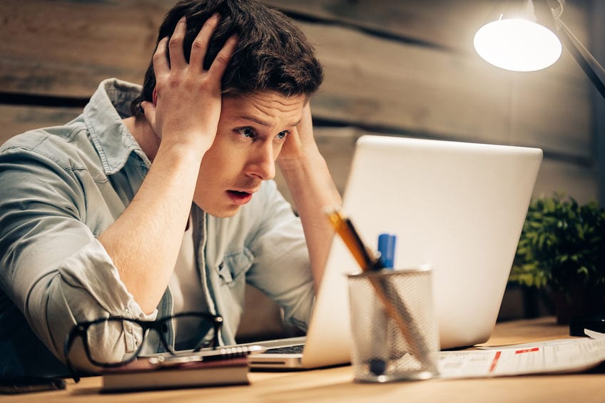 Image of frustrated man at laptop - online course failure