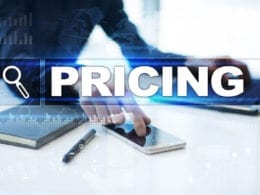 How to Price Online Courses - photo of person setting prices with calculator, laptop