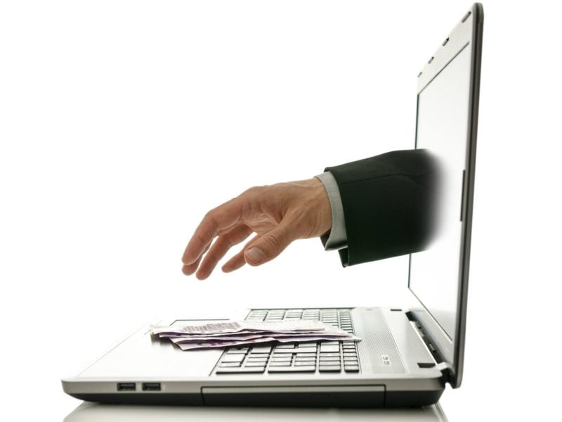 Hand reaching out of laptop for money