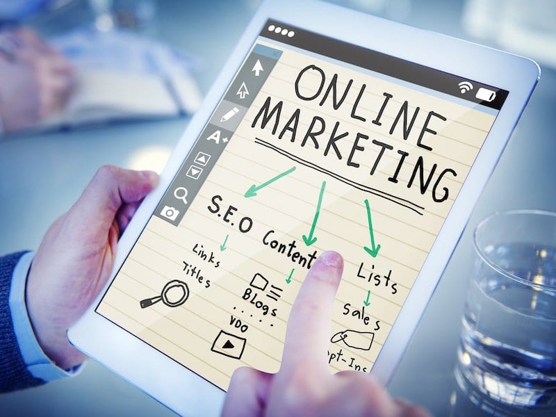 Hands holding tablet with "Online Marketing" - promote your masterclasss concept