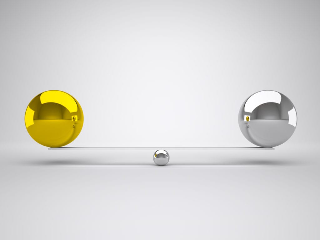 Gold and silver balls balanced against each other for Kartra vs Kajabi concept