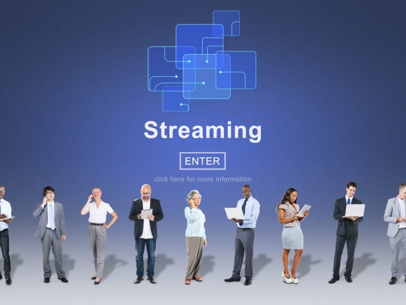 Multiple people on devices with text "Streaming" for livestreaming and multistreaming concept