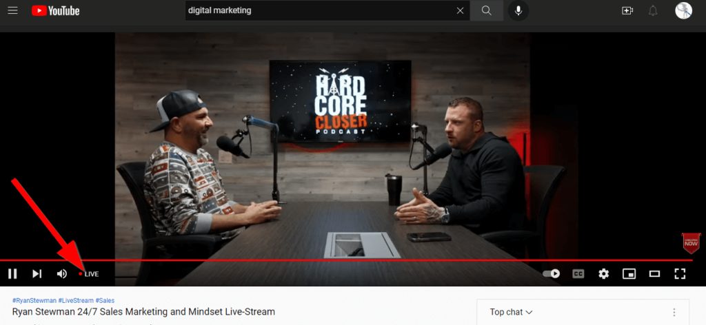 YouTube live stream, red arrow pointing at LIVE. Within the live stream, two men are engaged in conversation
