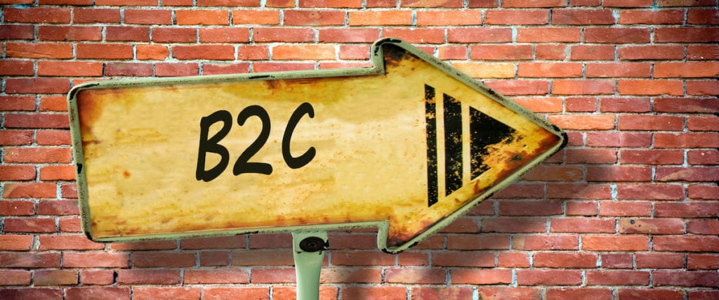 Letters b2c on right-facing wooden arrow against brick wall