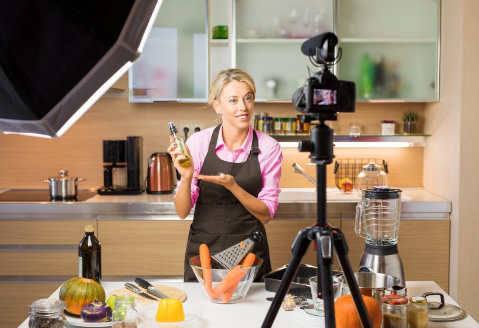 A woman records a training video for a cooking course.