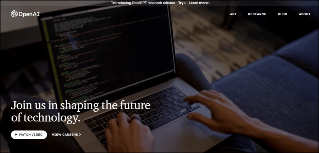 OpenAI home page "Join us in shaping the future of technology", image of hands typing on laptop in background