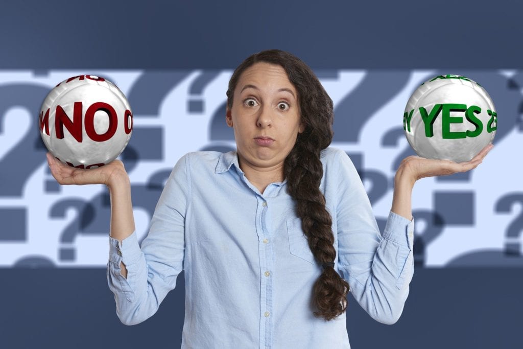 Woman balancing balls with No and Yes written on them - Is Kajabi pricing worth it concept