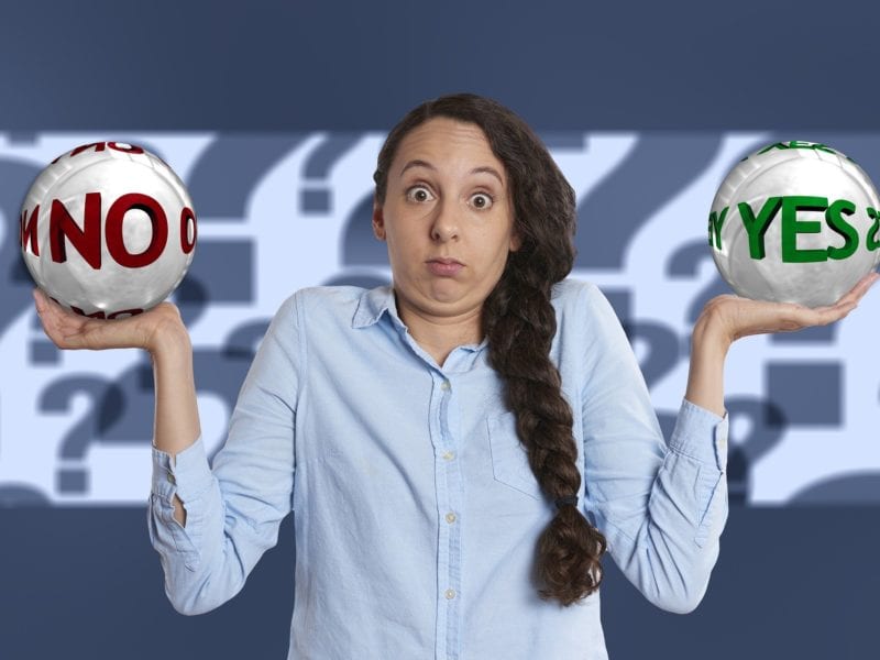 Woman balancing balls with No and Yes written on them - Is Kajabi pricing worth it concept